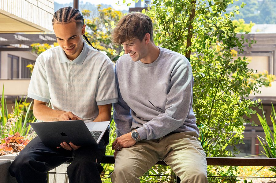 two friends looking at a laptop
